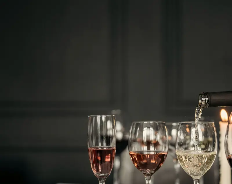Tre calici di rosato e di bianco mentre si versa il vino