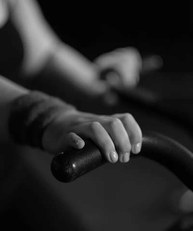 Una mano stretta sul manubrio di una bici da spinning.
