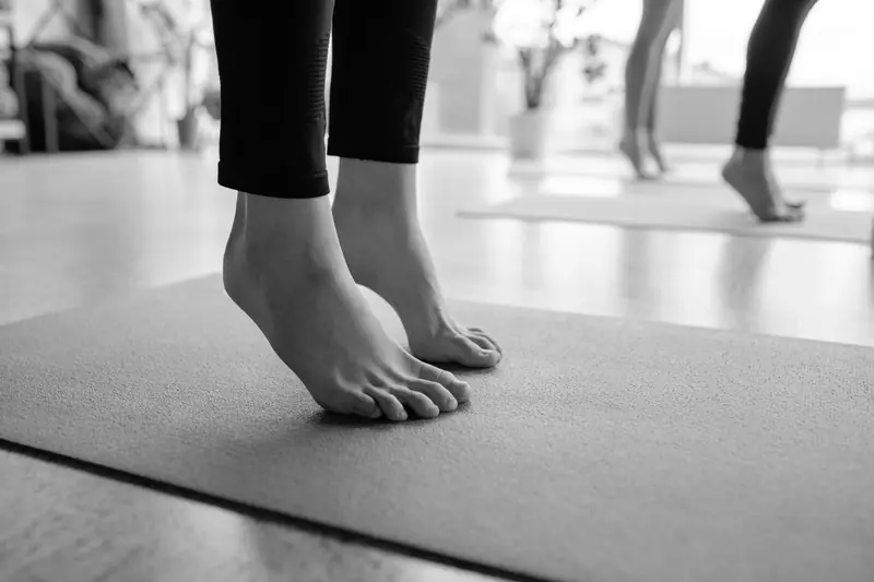 Piedi in punta su un tappetino, durante una lezione di pilates.